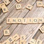 scrabble tiles spelling the word emotion on a wooden surface